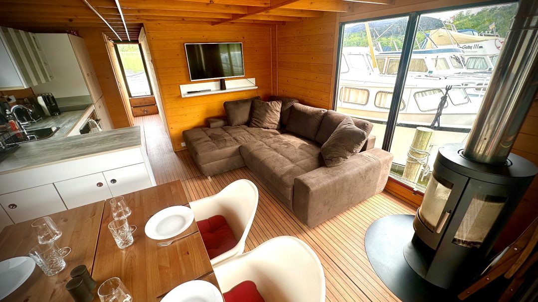 Moderne Wohnküche mit gemütlichem Sofa, Esstisch und Kamin.