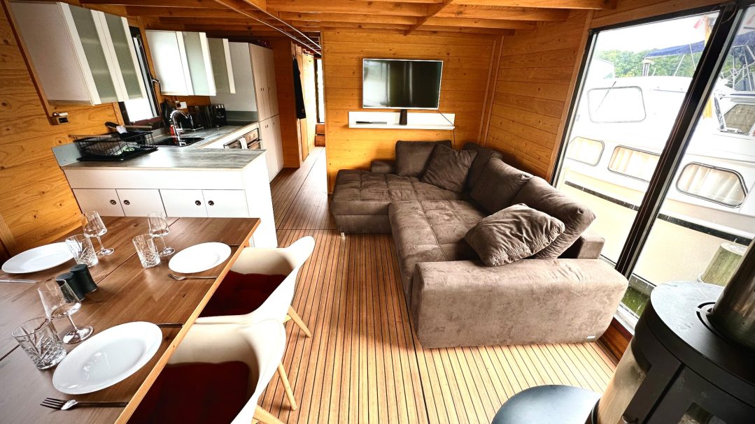 Moderne Holzwohnung mit einer gemütlichen Couch, Esstisch und offener Küche.