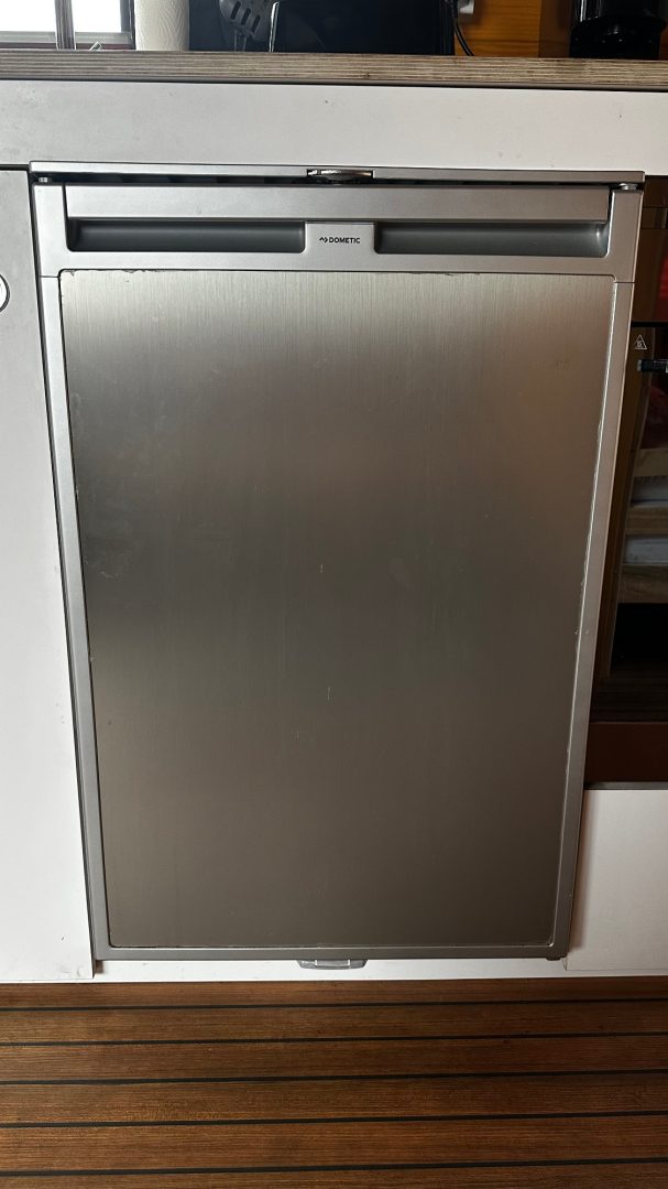 Edelstahl-Kühlschrank mit glatter Oberfläche, integriert in eine Küchenzeile.