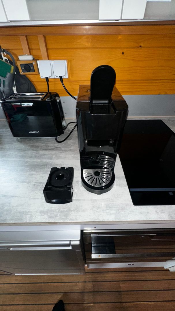 Küchenarbeitsplatte mit einer Kaffeemaschine, einem Toaster und weiteren Geräten.